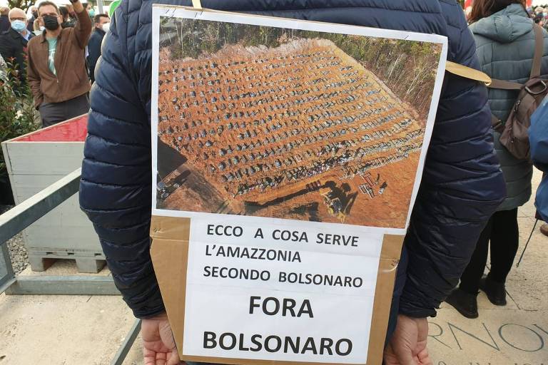 'É para isso que serve a Amazônia, segundo Bolsonaro', lê-se em cartaz com imagem de valas para vítimas da Covid-19 durante protesto na Itália