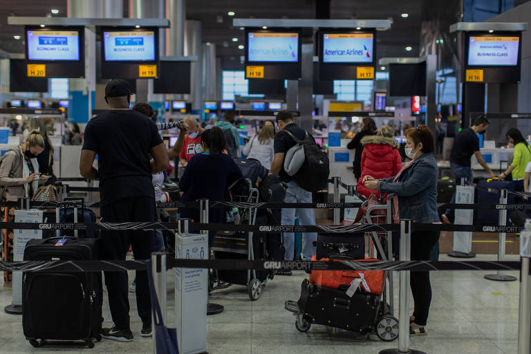 0Viajantes aguardam em fila no aeroporto de Guarulhos, em São Paulo 