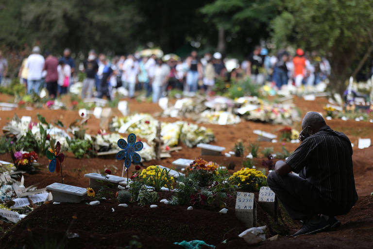 No cemitério de Vila Formosa, em São Paulo, pessoas rezam e homenageiam mortos, muitos deles devido à Covid