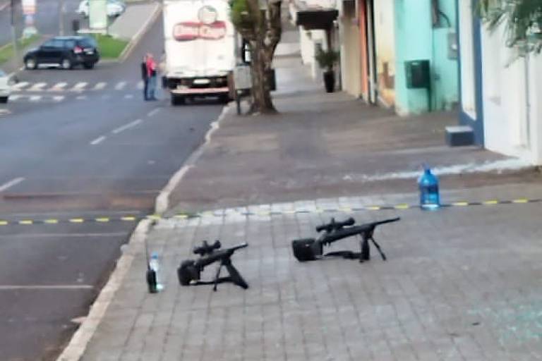 Imagem mostra armas no chão, na calçada
