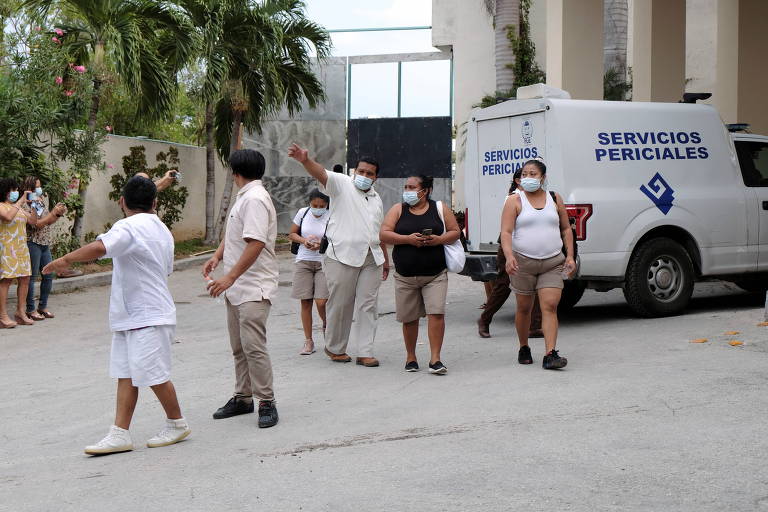 Trabalhadores do hotel na entrada do local depois que membros das gangues foram mortos em uma troca de tiros e a polícia