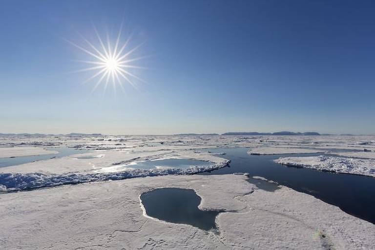 Imagem mostra um lago congelado. Ao fundo, se vê o sol.