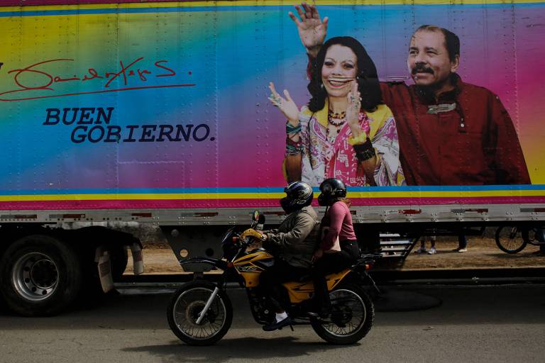 Motociclista passa por uma faixa do presidente da Nicarágua e candidato à presidência, Daniel Ortega, e sua esposa e companheira de chapa, Rosario Murillo, em Masaya
