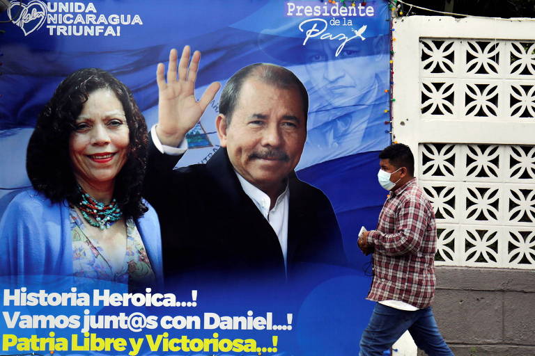 Homem caminha em frente a propaganda eleitoral do presidente da Nicarágua, Daniel Ortega, e a vice e esposa, Rosario Murillo, in Manágua, capital do país