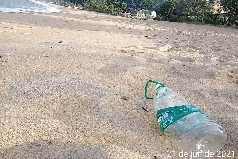 garrafa plástica na areia da praia