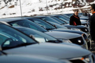 FILE PHOTO: People look at a line of Great Wall cars parked in front of the newly opened car factory of Great Wall Motor Co near the town of Lovech