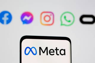 Facebook's new rebrand logo Meta is seen on smartpone in front of displayed logo of Facebook, Messenger, Intagram, Whatsapp, Oculus in this illustration taken