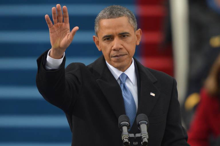 O então presidente dos EUA Barack Obama acena para o público ao tomar posse, em Washington

