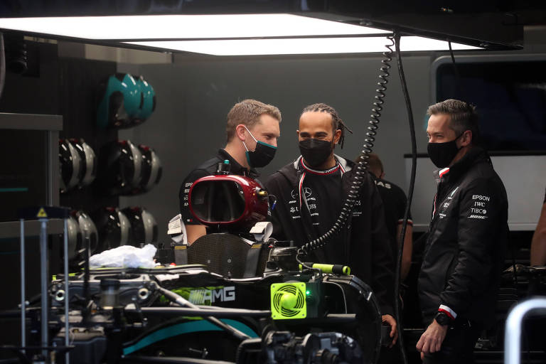 Lewis Hamilton (centro) em conversa com mecânicos da Mercedes