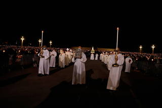 FILE PHOTO: Members of the clergy take part in a procession during the 104th anniversary of the appearance of the Virgin Mary to three shepherd children at the Catholic shrine of Fatima