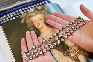 FILE PHOTO: A staff displays a pair of diamond bracelets before their auction sale in Geneva