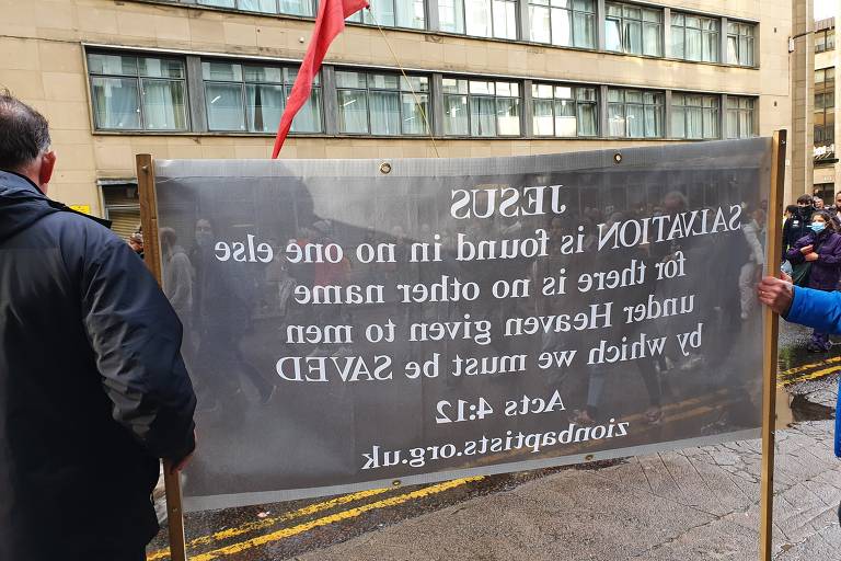 Sob chuva, manifestantes e população protesta contra a crise climática, durante a COP26, em Glasgow