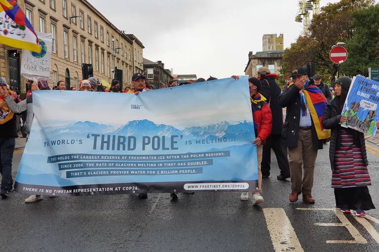 Sob chuva, manifestantes e população protesta contra a crise climática, durante a COP26, em Glasgow