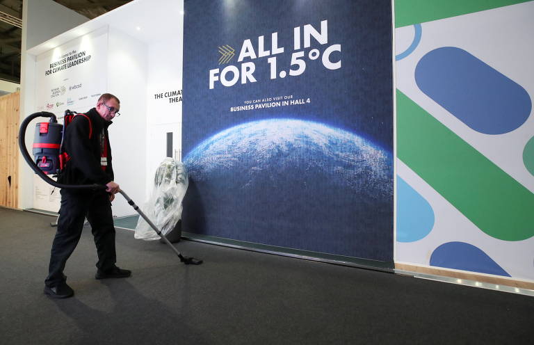 Funcionário limpa espaço por onde passam líderes globais, membros de comitivas dos países participantes e jornalistas