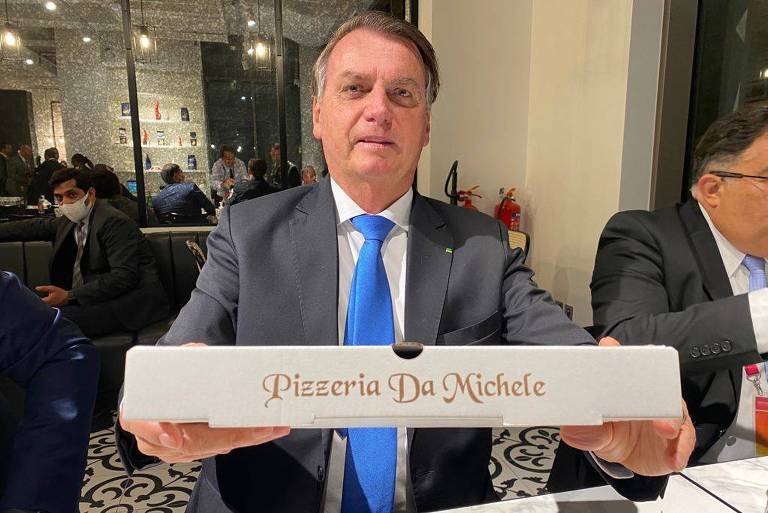 Bolsonaro segura caixa de pizza em que está escrito, Pizzeria da Michele