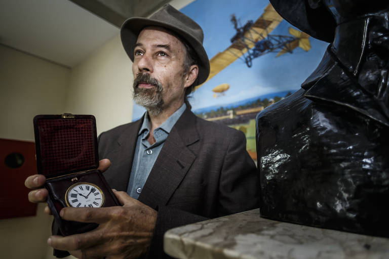 João Villares segura relógio que pertenceu ao parente Alberto Santos-Dumont; relógio marca 16h45, horário em que o aviador decolou em 12 de novembro de 1906, no Campo de Bagatelle, em Paris