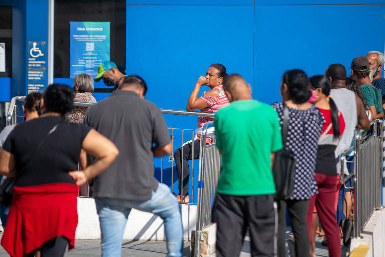 Dezenas de pessoas aguardam em fila na porta da Caixa em agência do Jaçanã, zona norte da capital paulista
