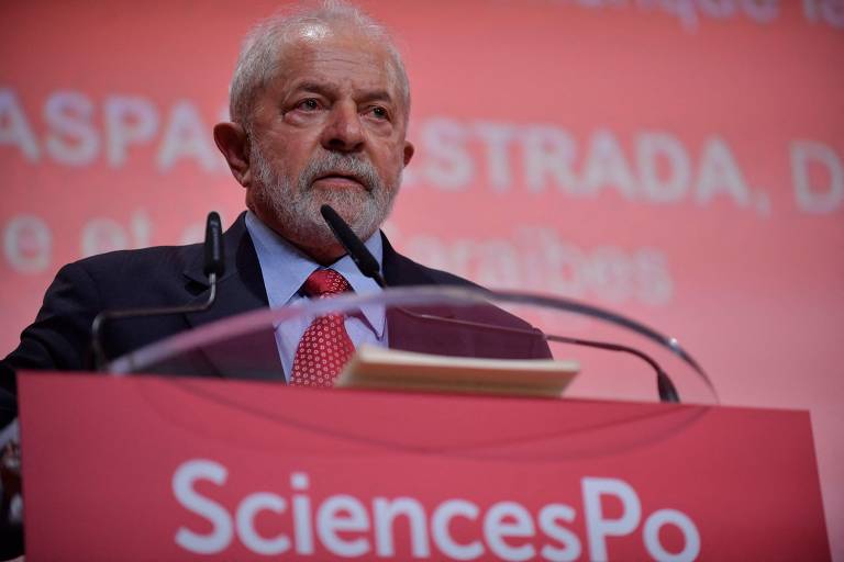 Lula está em púlpito de cor avermelhada com microfone onde se lê "Sciences Po"