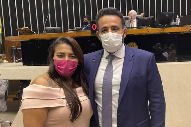 Mulher e homem, de máscara, abraçados no plenário da Câmara