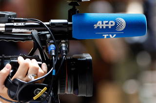 FILE PHOTO: A journalist holds a camera as she covers a trial at Paris courthouse