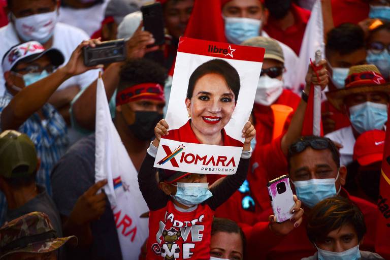 Apoiadores de Xiomara Castro, principal nome da oposição na eleição hondurenha à Presidência, seguram retrato da candidata na cidade de San Lorenzo