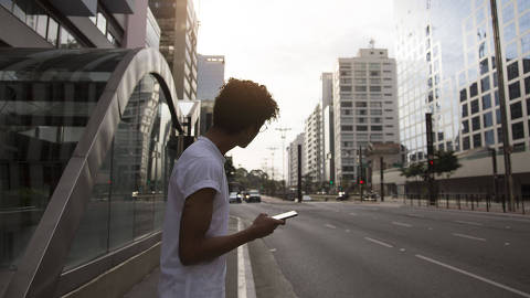 Jovem a espera de transporte de aplicativo na cidade de São Paulo- BrasilLifestyle
