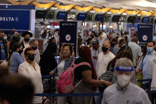 FILE PHOTO: Passengers gather near Delta airline's counter as they check-in their luggage at Hartsfield-Jackson Atlanta International Airport, in Atlanta