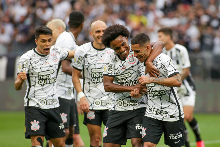 O volante Gabriel (dir.) é abraçado pelo meia-atacante Willian após marcar o seu gol, o segundo do Corinthians na vitória no clássico sobre o Santos