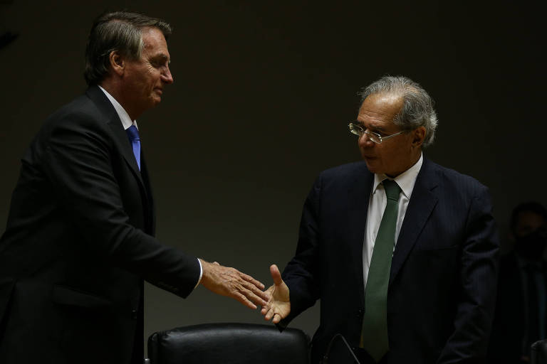 O presidente Jair Bolsonaro e o ministro da Economia Paulo Guedes se dão as mãos