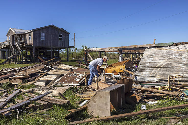 Benny Dardar, 70, procura objetos em meio a escombros de sua casa, na ilha de Jean Charles