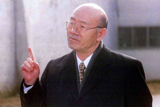 FILE PHOTO: Former South Korean president Chun Doo-hwan, standing outside the walls of Anyang Prison, makes a point shortly after being released from the jail on a special pardon in Anyang