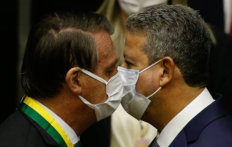 O presidente Jair Bolsonaro (esq.), de máscara, ao lado do presidente da Câmara, Arthur Lira