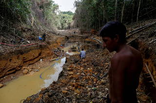FILE PHOTO: A Yanomami indian follows agents of Brazil's environmental agency in a gold mine during an operation against illegal gold mining on indigenous land, in the heart of the Amazon rainforest