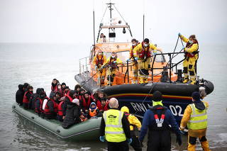 Migrants are escorted ashore by a RNLI Lifeboat, after having crossed the channel, in Dungeness