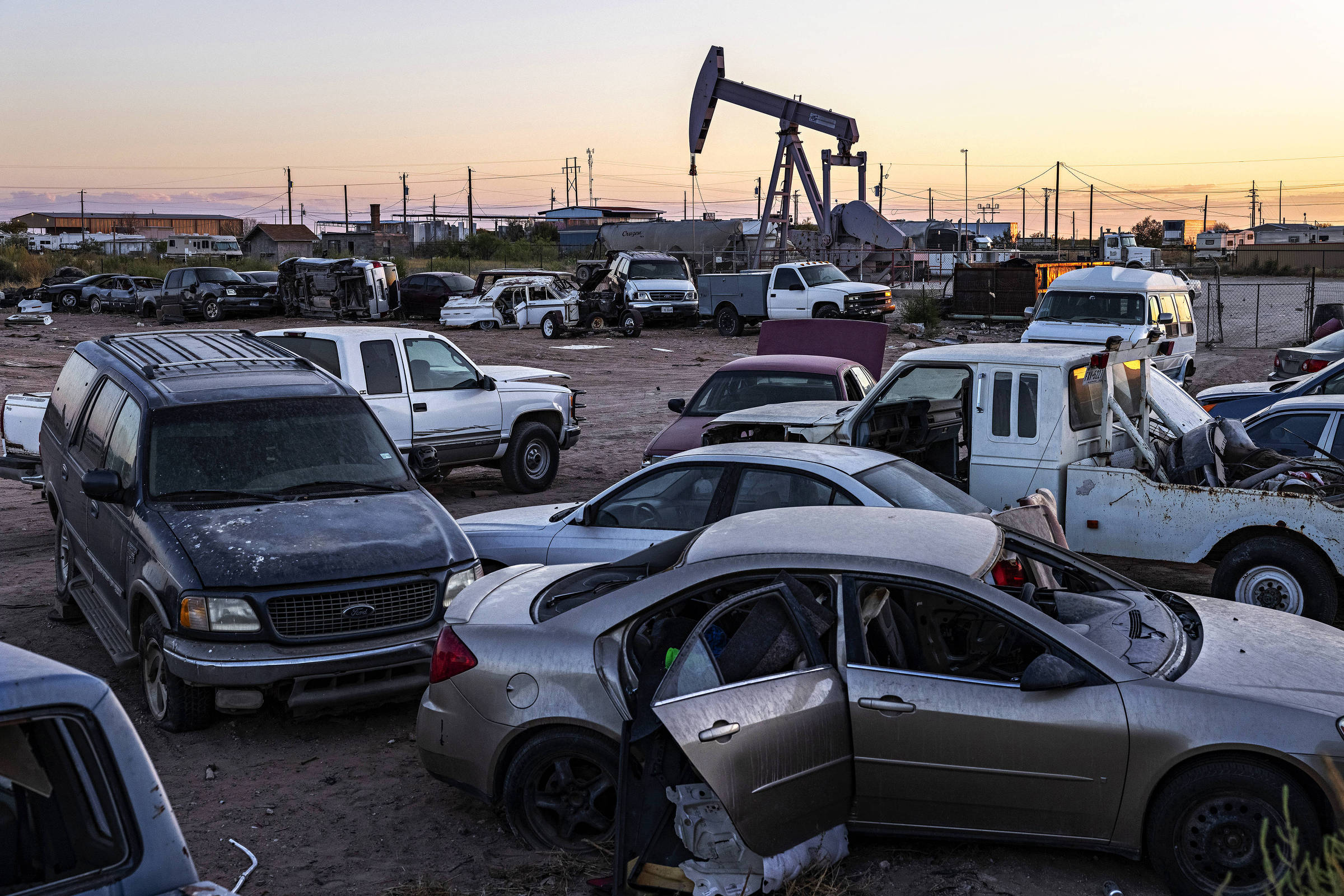 Poço de extração de petróleo ao lado de ferro-velho próximo à cidade de Odessa, no estado do Texas