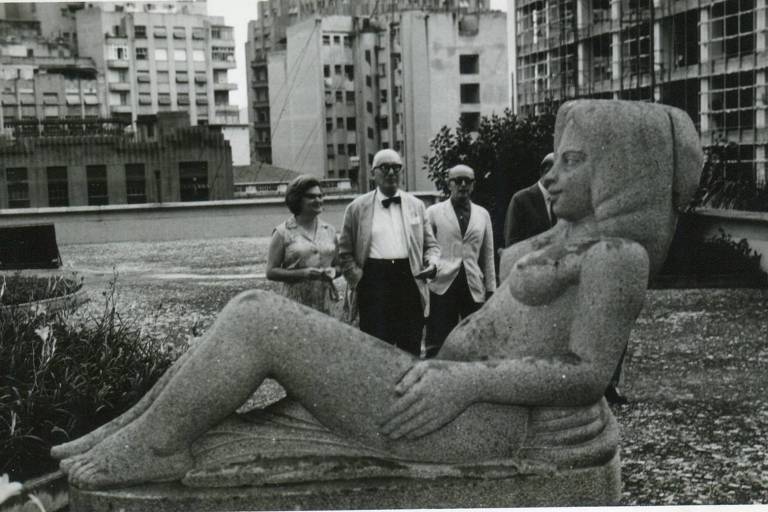 grupo de pessoas observa estátua