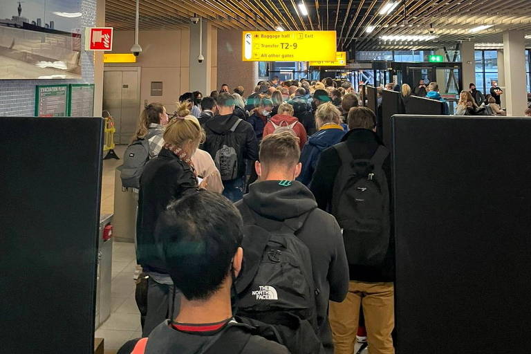 Passageiros vindos da África do Sul em fila para teste de Covid-19 no aeroporto de Schiphol, em Amsterdã (Holanda)
