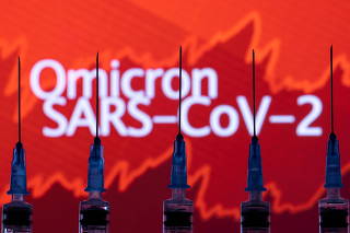 Syringes with needles are seen in front of a displayed stock graph and words 