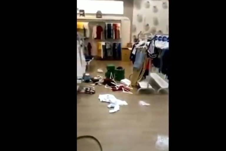 A imagem mostra roupas jogadas no chão dentro de uma loja