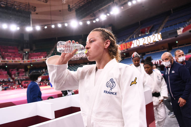 Judoca toma água em frente a tatame