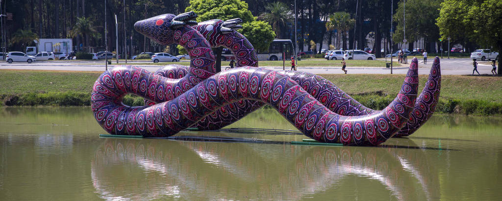 Duas esculturas de cobras infláveis boiam sobre lagoa no parque Ibirapuera