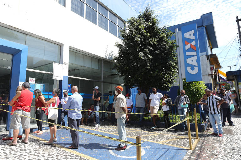 Pessoas formam fila em frente à agência da Caixa. Há um logo azul, do lado direito, com o nome da Caixa