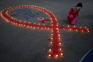 A girl lights earthen lamps during an HIV/AIDS awareness campaign on the occasion of World AIDS Day in Kolkata