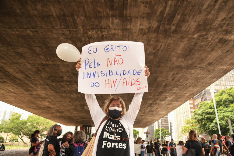 Mulher ergue cartaz no ato em alusão ao Dia Mundial de Luta contra a Aids no vão do MASP, em São Paulo