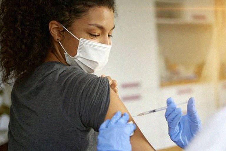 Mulher negra no canto esquerdo da foto recebendo uma aplicação de vacina