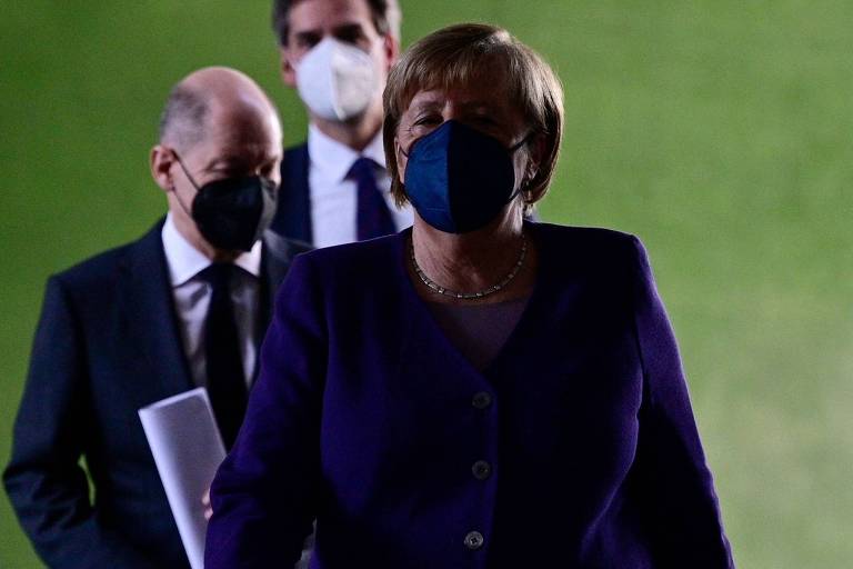 A primeira-ministra alemã, Angela Merkel, e o futuro premiê do país, Olaf Scholz, após discurso em que anunciaram as novas medidas
