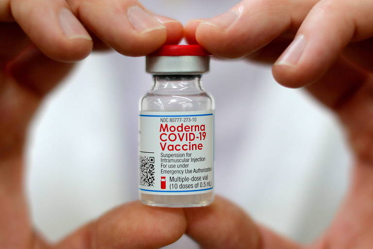 Pessoa segura um frasco da vacina da Moderna