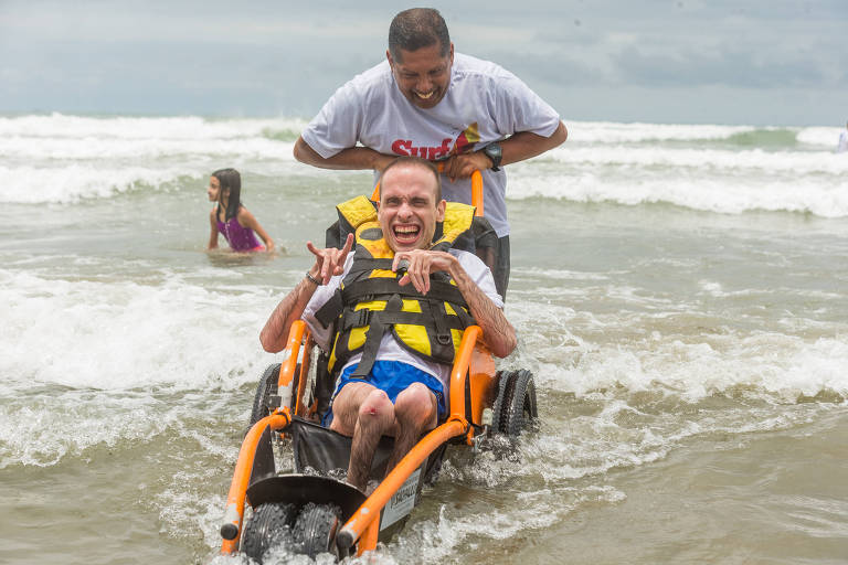 Adriano Pereira, 35 anos, de São Bernardo do Campo (ABC), entra no mar com cadeira anfíbia