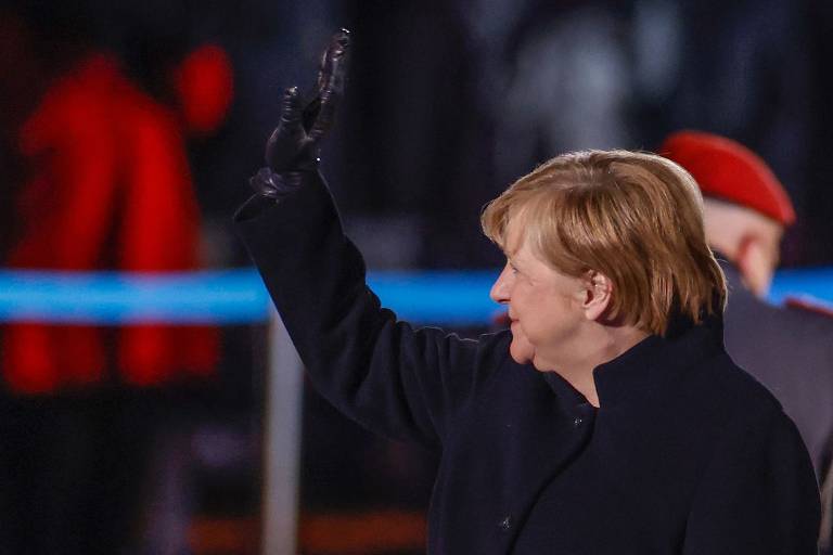 Angela Merkel acena para pessoas presentes na cerimônia Grosser Zapfenstreich, que marca sua saída do cargo de primeira-ministra da Alemanha após 16 anos