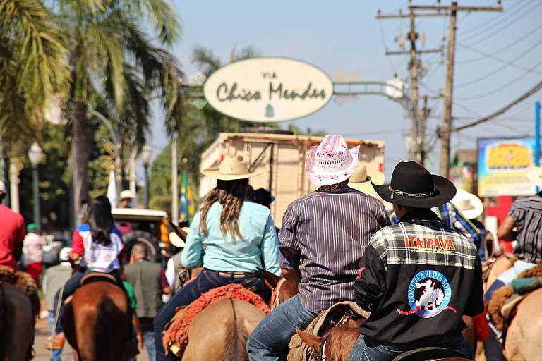 Cavaleiros cavalgam sobre seus cavalos usando chapéu de cowboy na Via Chico Mendes, em Rio Branco (AC)